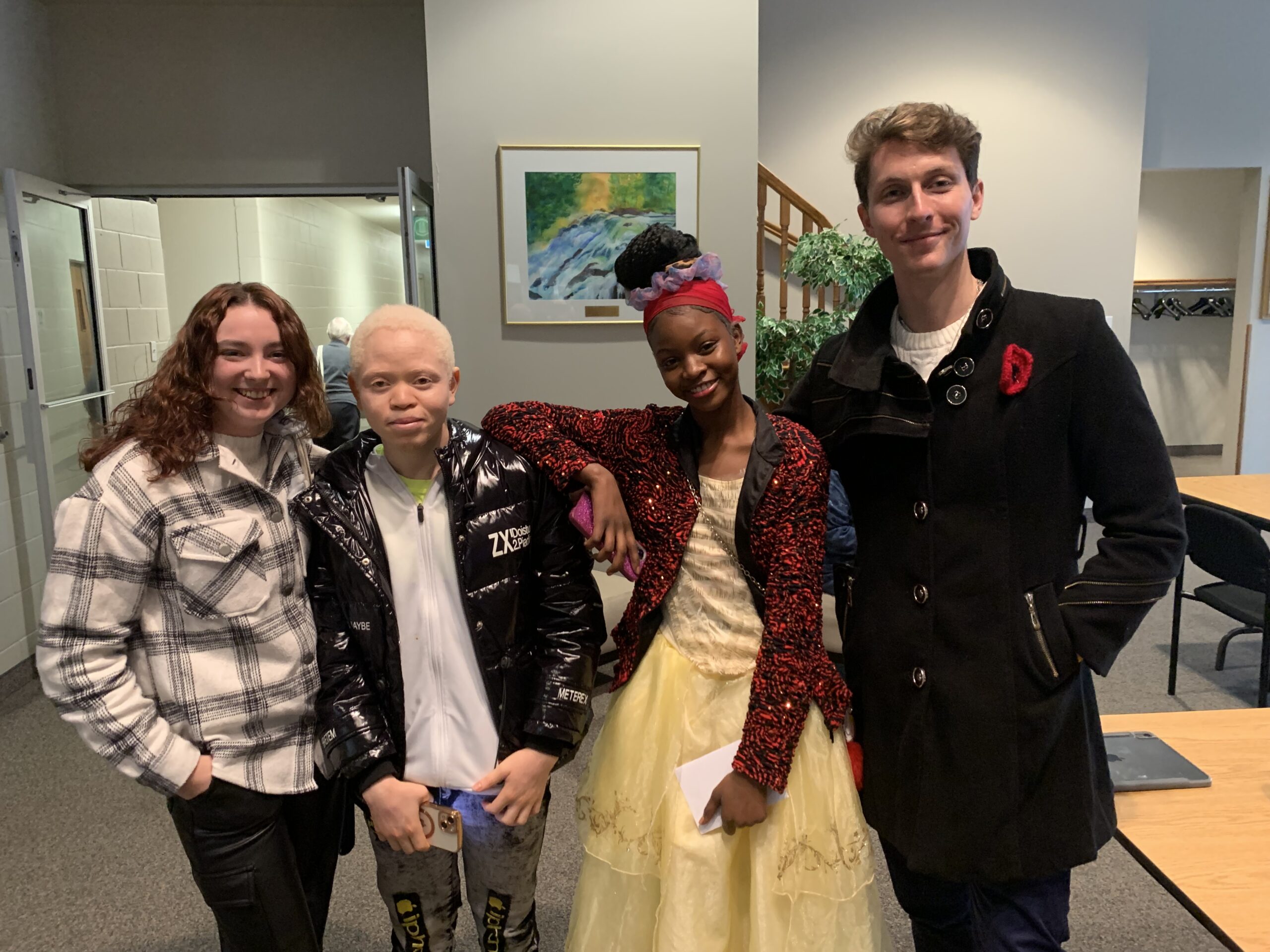 four standing youth named kyla, jackson, sifa and connor in the background is a wall with a picture, these people are climate motivators